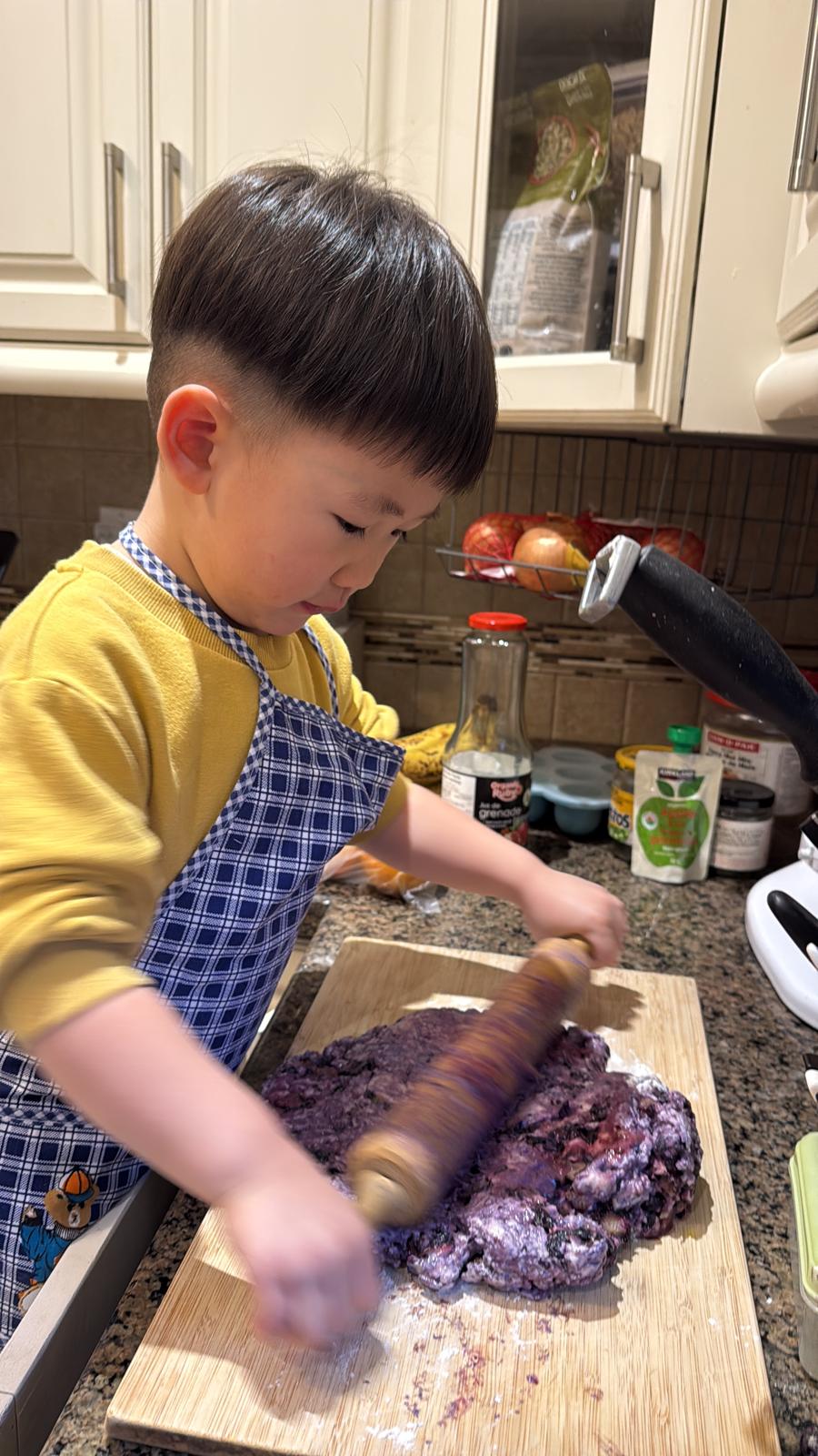 Our little one rolling out dough in the kitchen